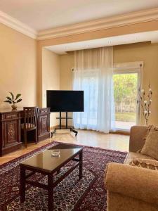 a living room with a couch and a tv at Elegant Villa in Sheikh Zayed City, Egypt - Families Only in Sheikh Zayed
