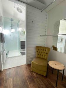 a bathroom with a yellow chair and a shower at Sylvester’s on Lamont. Arty in Invermay. in Invermay