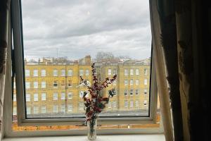 a vase filled with flowers sitting in a window at Baker Street 2 Bed Apartment in London