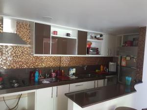 a kitchen with white cabinets and a black counter top at Solar Camorim in Angra dos Reis