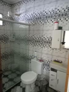 uma casa de banho com um WC e uma cabina de duche em vidro. em Casa em berlinque, vera cruz. em Vera Cruz de Itaparica