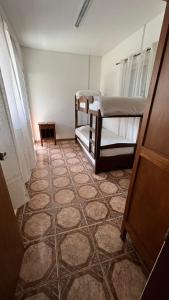 a room with two bunk beds and a tiled floor at Casa cabaña in Paysandú