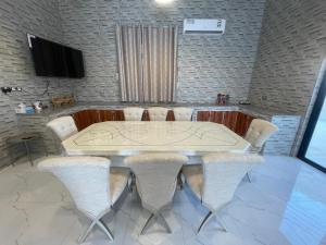une salle de conférence avec une table et des chaises blanches dans l'établissement Tiwi Pearl, à Sour