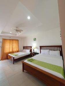 a bedroom with two beds and a ceiling at Moalboal Tropics in Moalboal