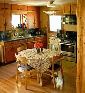 eine Küche mit einem Tisch und einer Blumenvase darauf in der Unterkunft Fivespot Cabin in Pinehurst