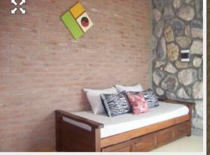 Villa Pio في هويرتا غراندي: مقعد عليه وسائد بجانب جدار من الطوب