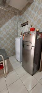 a kitchen with a refrigerator and a table and a chair at Quarto Casal Térreo perto Pelourinho in Salvador