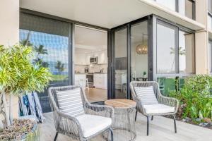 two wicker chairs and a table on a patio at KIHEI SURFSIDE #110 condo in Wailea