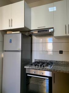 uma cozinha com um fogão e armários brancos em Private and cosy room in a shared apartment em Agadir