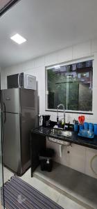 a kitchen with a sink and a refrigerator at Studio RD in Angra dos Reis