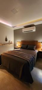 um quarto com uma cama grande com duas luzes em Studio RD em Angra dos Reis