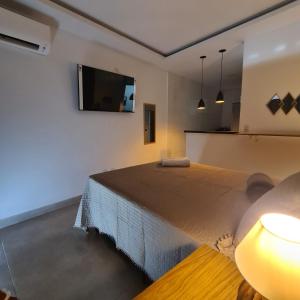 um quarto com uma cama e uma televisão de ecrã plano em Studio RD em Angra dos Reis