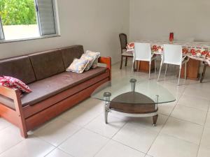 un soggiorno con divano e tavolo di Apartamento de 3 quartos em Jurerê a Florianópolis