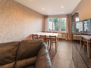 ein Wohnzimmer mit einem Sofa, einem Tisch und Stühlen in der Unterkunft Magnificent accommodation for 7 travellers with hot tubs in Esneux