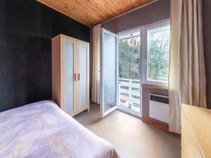 ein Schlafzimmer mit einem Bett und einem großen Fenster in der Unterkunft Magnificent accommodation for 7 travellers with hot tubs in Esneux
