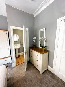 a bedroom with a dresser with a sink and a mirror at Stay In Oxford Street in London