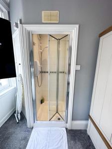 a shower with a glass door in a bathroom at Stay In Oxford Street in London