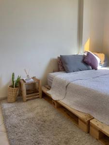 um quarto com uma cama de madeira e uma mesa em Private and cosy room in a shared apartment em Agadir