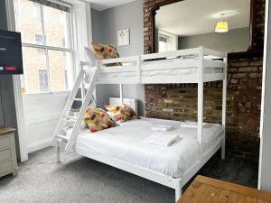 a bedroom with two bunk beds and a ladder at Stay In Oxford Street in London