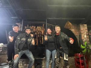 un groupe de quatre hommes posant une photo dans l'établissement Homestay Bách Thảo Tà Lùng, 