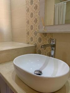um lavatório branco na casa de banho com um espelho em Private and cosy room in a shared apartment em Agadir