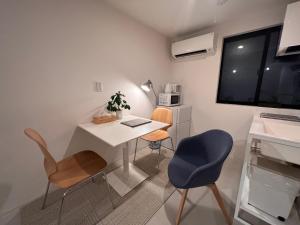 Cette petite chambre comprend un bureau et deux chaises. dans l'établissement Oku-Shibu Residence, à Tokyo
