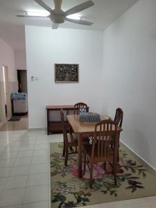 une salle à manger avec une table et des chaises sur un tapis dans l'établissement Che Ta Homestay for musliim only, à Kampong Geliga Besar