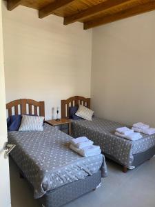 dos camas sentadas una al lado de la otra en una habitación en Departamento Alberdi - Cochera privada y techada en Godoy Cruz