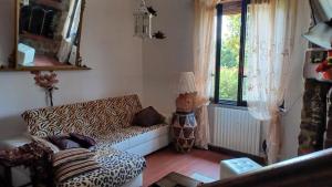 - un salon avec un canapé à motifs léopard et une fenêtre dans l'établissement Casale Toscano in aperta campagna, à Figline Valdarno