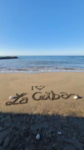 un cartel escrito en la arena de la playa en Hotel Partenon Beach en La Ceiba
