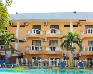 um hotel com piscina em frente a um edifício em Hotel Partenon Beach em La Ceiba