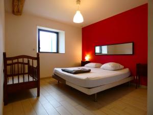 a bedroom with a bed with a red wall at Gîte Moutiers, 9 pièces, 15 personnes - FR-1-581-125 