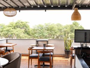 restauracja ze stołami i krzesłami oraz dużym oknem w obiekcie Rua Hoteles Piura w mieście Piura