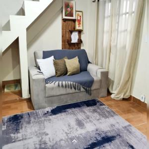 a living room with a couch and a rug at Hospedagem Doce Lar - Casa Azaleia in Teresópolis