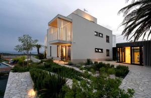 a large white house with a lot of windows at Luxury villa with a swimming pool Palit, Rab - 22153 in Rab