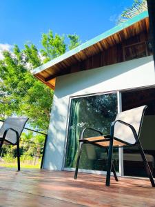 two chairs and a table on a deck at Ficus house in Boca Tapada