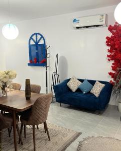 a living room with a blue couch and a table at منتجع شاطيء غوفالي GUVALI Beach شاليه طراز ميكانوس Siyal سيال سابقاً in Jeddah