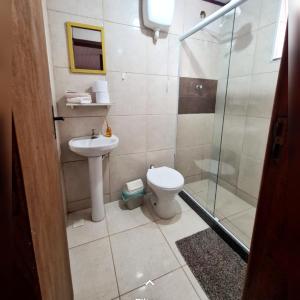 a bathroom with a shower and a toilet and a sink at Hospedagem Doce Lar - Casa Azaleia in Teresópolis