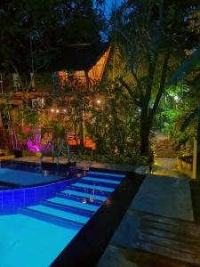 a swimming pool lit up at night at Levona Garden Resort in Habarana