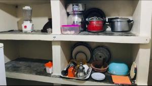 un estante con ollas, sartenes y otros artículos de cocina en Maison d’hôtes ATLAS ait alla, en Tan-Tan Plage