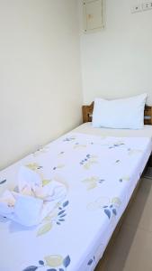 Una cama blanca con flores en una habitación en Charlina Inn Panglao, en Panglao