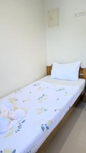 a bed with a white sheets and blue flowers on it at Charlina Inn Panglao in Panglao