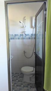 a bathroom with a shower and a toilet at Charlina Inn Panglao in Panglao