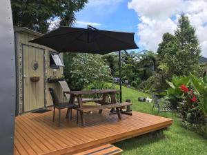 a wooden deck with a picnic table and an umbrella at The Dome Waikino in Waikino
