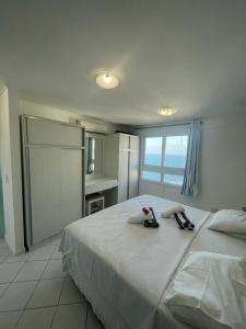 a bedroom with a large white bed with towels on it at Marina Bezerril - 304 Pontamares - O melhor de Natal in Natal