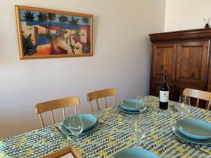 a dining room table with a bottle of wine and glasses at Porto Santo Happy Place in Porto Santo