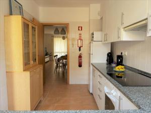 a kitchen with white cabinets and a counter top at Porto Santo Happy Place in Porto Santo