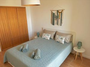 a bedroom with a bed with slippers on it at Porto Santo Happy Place in Porto Santo