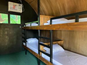 a room with three bunk beds in a house at Funtasea Hotel and Beach Resort in Iba