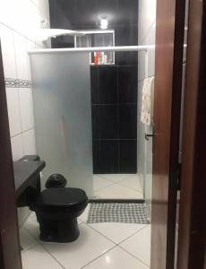 聖馬特烏斯的住宿－Casa de praia em Guriri，一间带黑色卫生间和淋浴的浴室